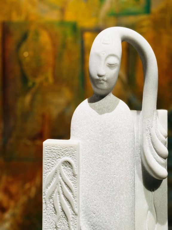 白色石雕作品的特寫，人物面容靜謐