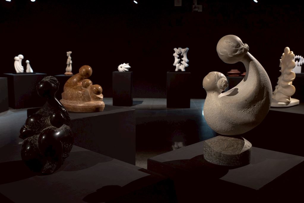 多件雕塑作品陳列於昏暗的展廳中